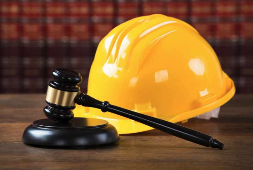 A judge 's gavel and construction helmet on top of a table.